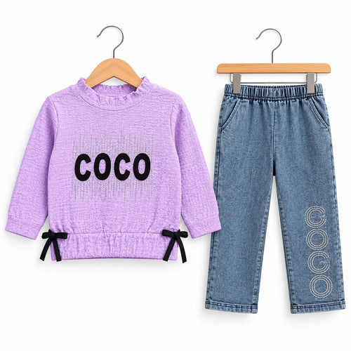 A toddler girl's two-piece clothing set featuring a lavender waffle-knit long-sleeve top with 'COCO' printed in black on the front, paired with light blue denim pants with black and white circular patterns on the lower leg. The set is displayed on wooden hangers against a plain white background.