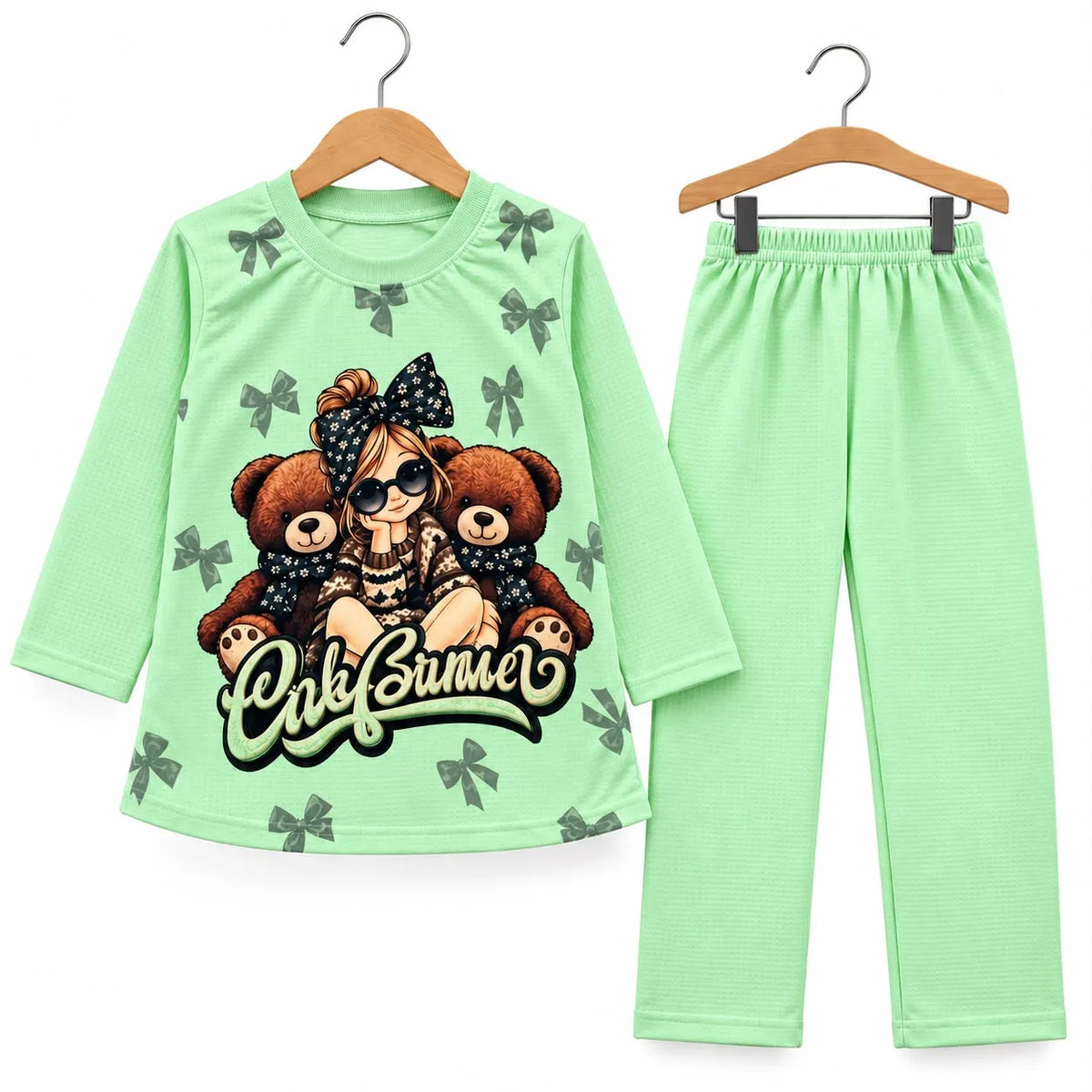 A two-piece children's pajama set consisting of a long-sleeve top and matching pants in light mint green. The top features a graphic print of a girl with a polka-dot bow and sunglasses surrounded by brown teddy bears, with the text 'Only Sumo' across the front.